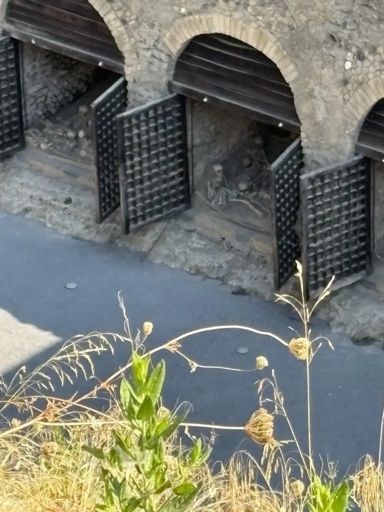 Ancient rooms with stone arches and surviving wall paintings at Herculaneum
