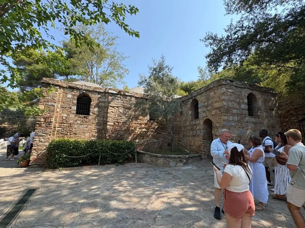 Stone chapel known as the House of the Virgin Mary with visitors waiting outside near Ephesus