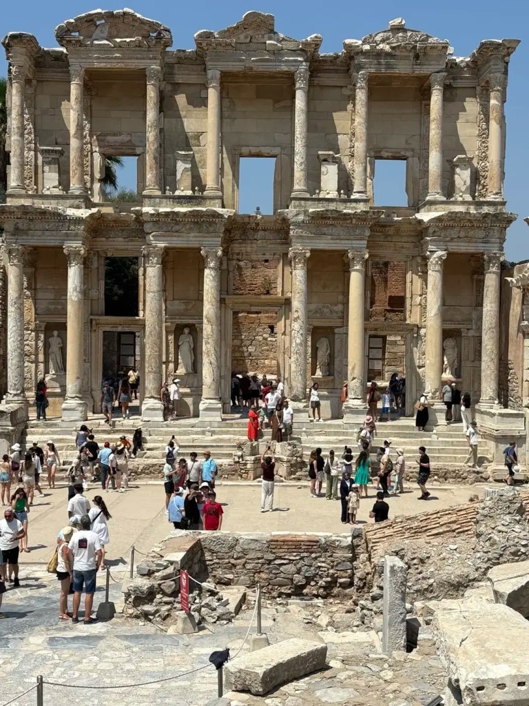 Restored facade of the Library of Celsus surrounded by visitors at ancient Ephesus
