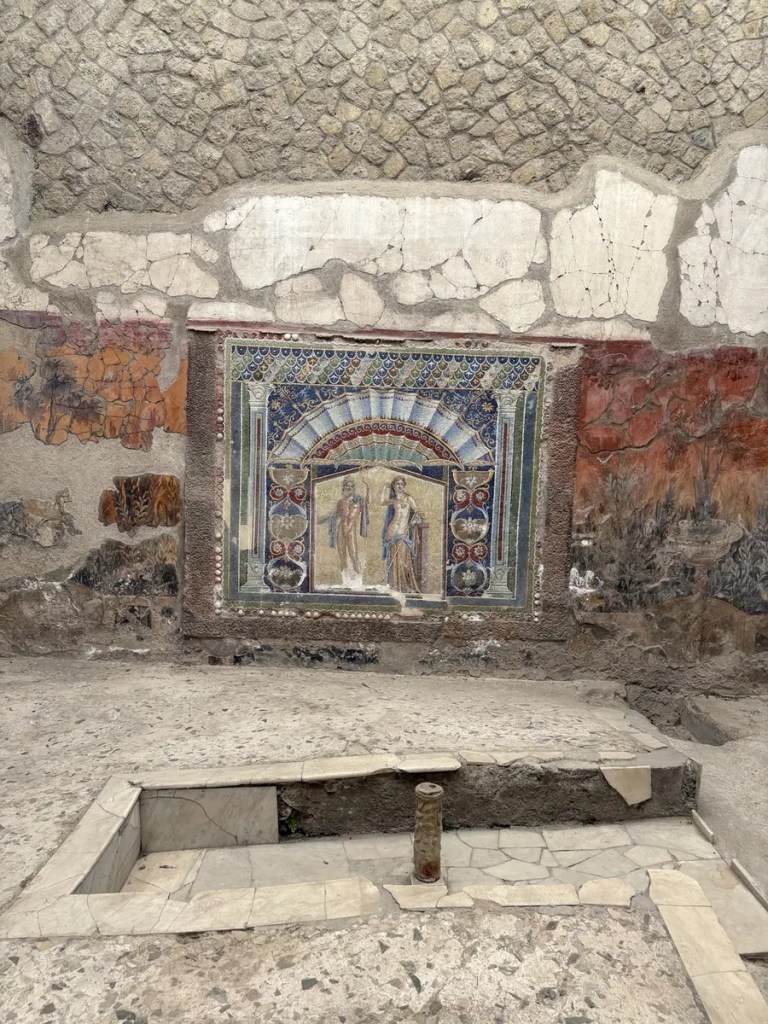 Colorful ancient mosaic of Neptune and Amphitrite surrounded by decorative panels at Herculaneum