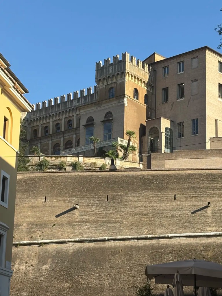 Historic buildings and fortified walls near Vatican City under a clear blue sky