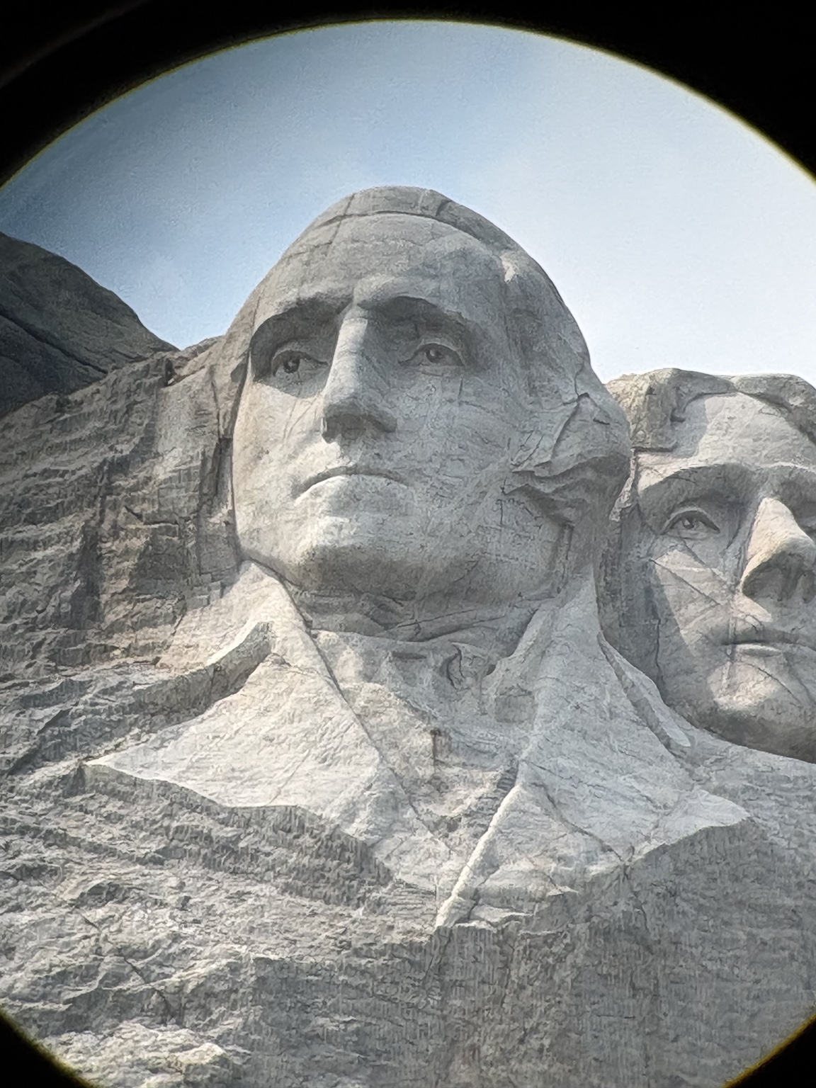 Close-up of George Washington's carved face at Mount Rushmore, with part of Thomas Jefferson visible.