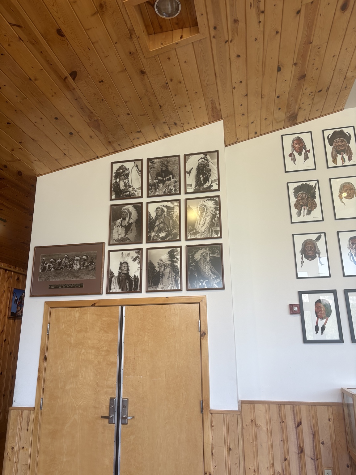 Framed photographs and portraits displayed on a museum wall at Crazy Horse Memorial.